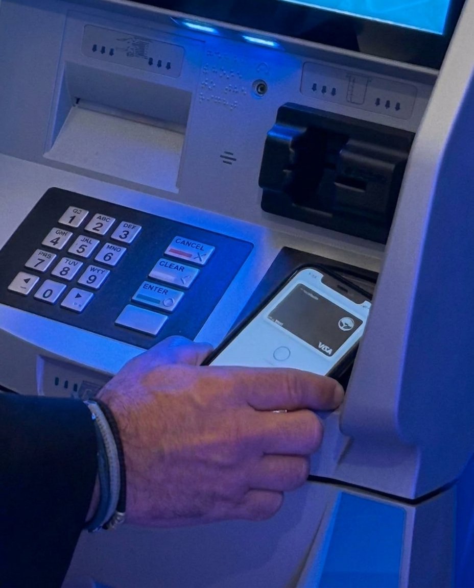 A phone wallet tapped on the contactless reader of an ATM